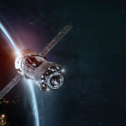 Artificial satellite orbiting Earth with visible solar panels and atmospheric glow in the background, representing advanced space technology.