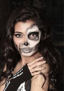Half-painted skeleton halloween makeup design showing one natural side and one spooky skull design.