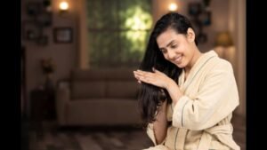 A girl applying homemade hair oil to her scalp for smooth and shiny hair
