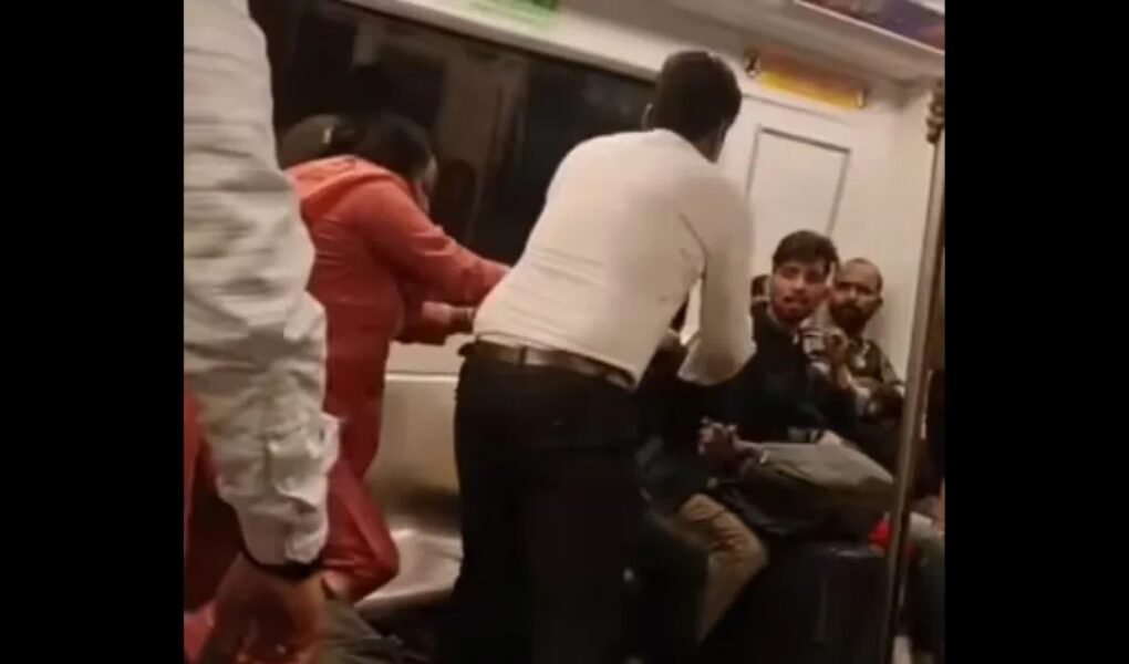 Viral video shows two passengers fighting inside a crowded Delhi Metro coach as shocked commuters look on.