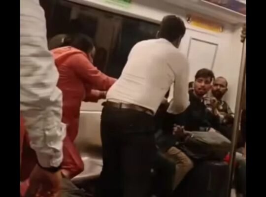 Viral video shows two passengers fighting inside a crowded Delhi Metro coach as shocked commuters look on.