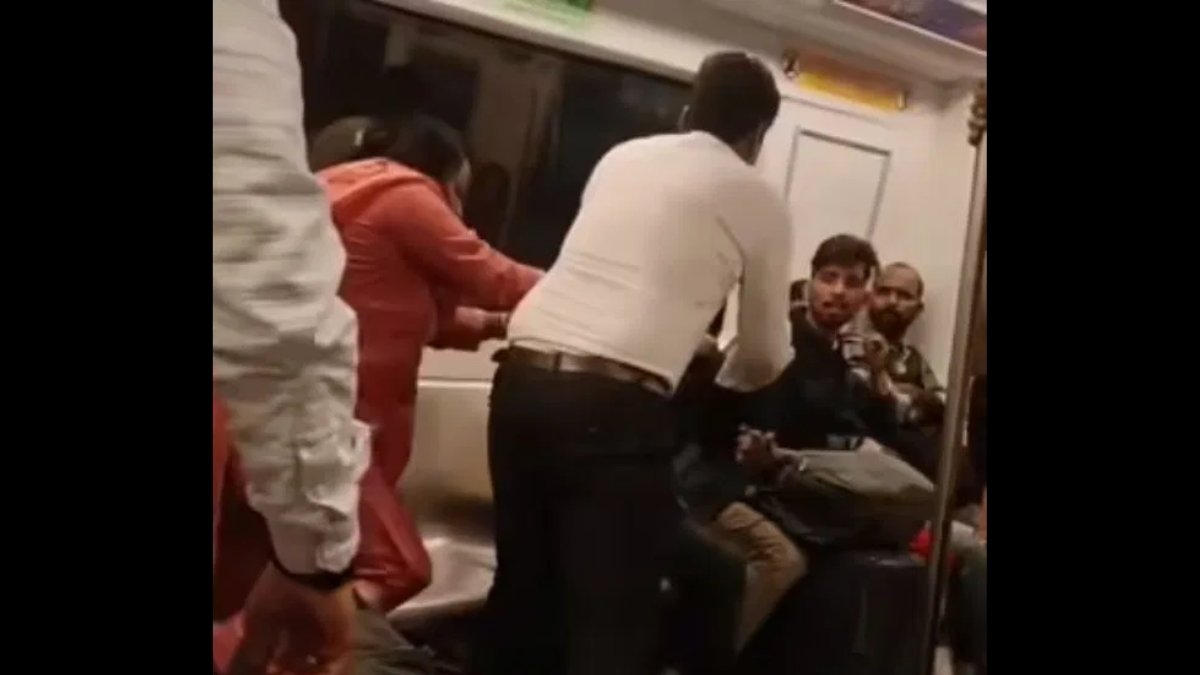 Viral video shows two passengers fighting inside a crowded Delhi Metro coach as shocked commuters look on.