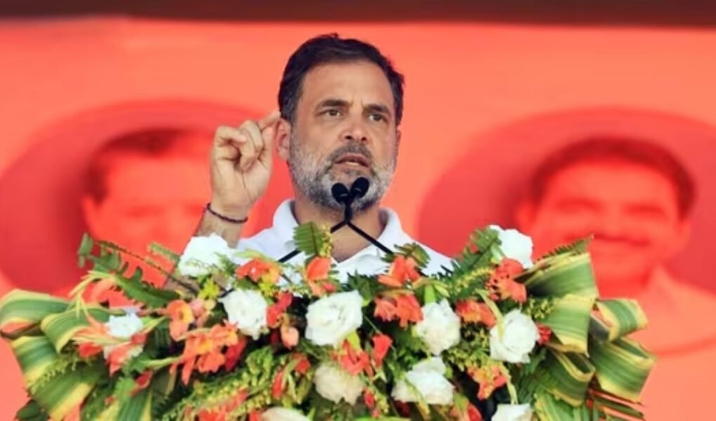 Indian politician Rahul Gandhi speaking passionately at a podium decorated with orange and white flowers during a political rally, central to today's political **NEWS** headlines.