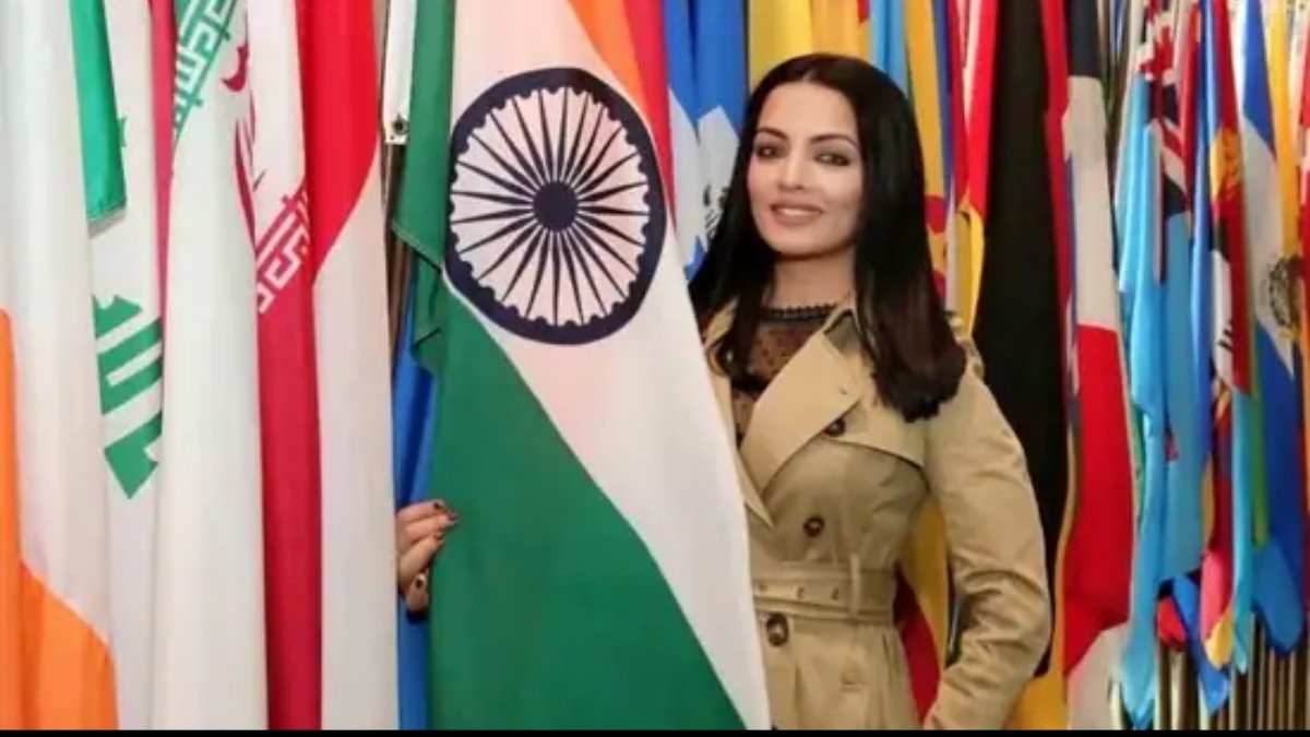 Bollywood actress Celina Jaitly standing beside Indian flag at an international event
